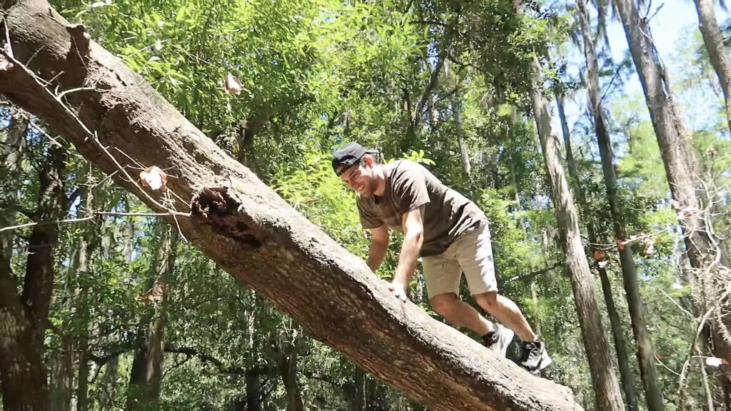 Kyle Pallo climbing a log